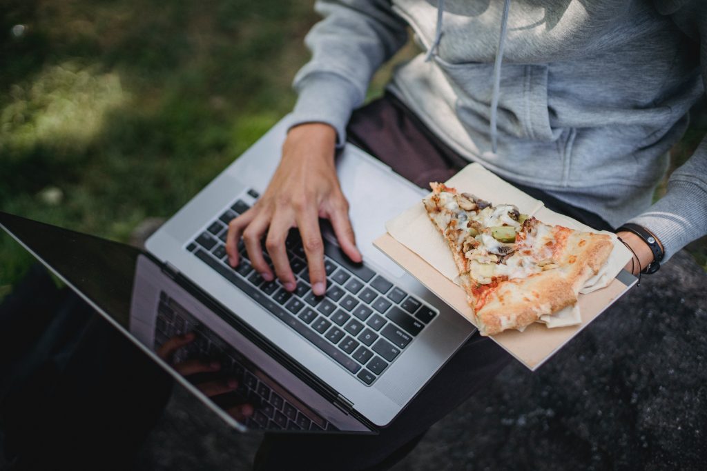 typing strong keywords on a computer while eating pizza